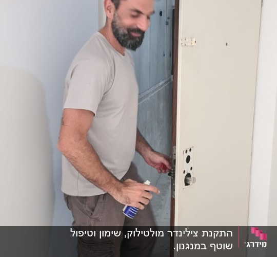 אדם מתקן מנעול דלת עם כלי עבודה.